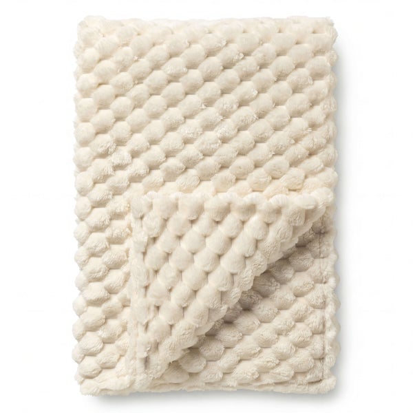 Cremeweiße Kuscheldecke mit Noppenstruktur aus weichem Plüsch.