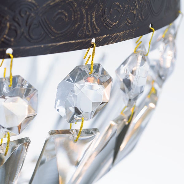 Detailansicht einer Pendelleuchte mit Metallrahmen und Kristallbehang als Dekoration.