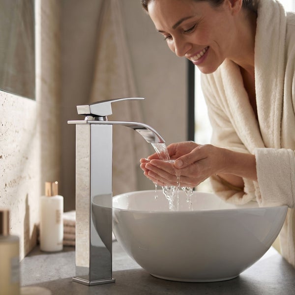 Moderne hohe Waschtischarmatur aus Chrom an einem runden Aufsatzwaschbecken in einem hellen Badezimmer.