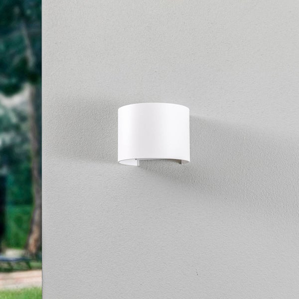 Weiße Außenwandleuchte in halbrunder Form an einer strukturierten Fassade.