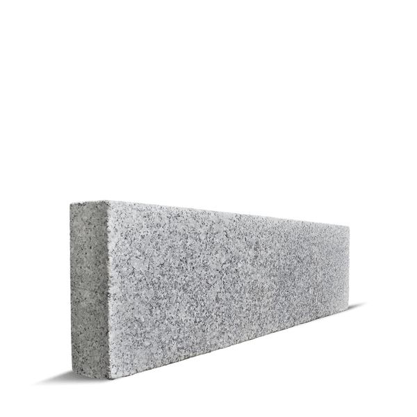 Graue rechteckige Rasenkante aus Granit mit grober Oberflächenstruktur.