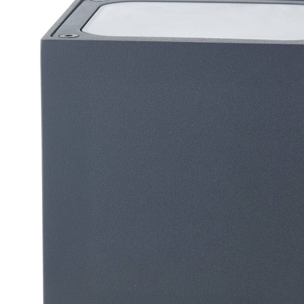 Nahaufnahme einer quadratischen, anthrazitfarbenen Außenwandleuchte mit strukturierter Oberfläche und weißem Glas.