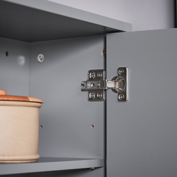 Detailansicht eines grauen Schranks mit Topf und Scharnier