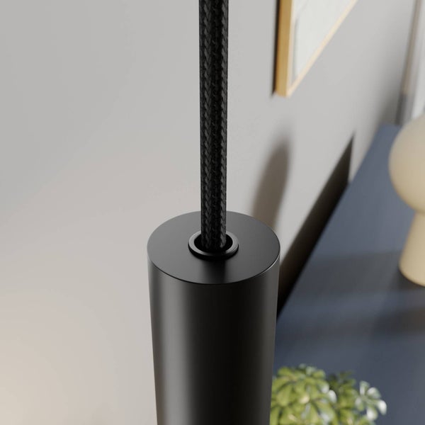 Detailaufnahme einer Pendelleuchte mit schwarzem zylindrischem Metallgehäuse und schwarzem Textilkabel.