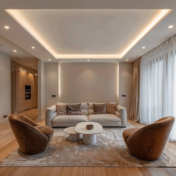 Modernes Wohnzimmer mit hellem Sofa, braunen Sesseln, Marmortischen, indirekter Deckenbeleuchtung und Parkettboden.