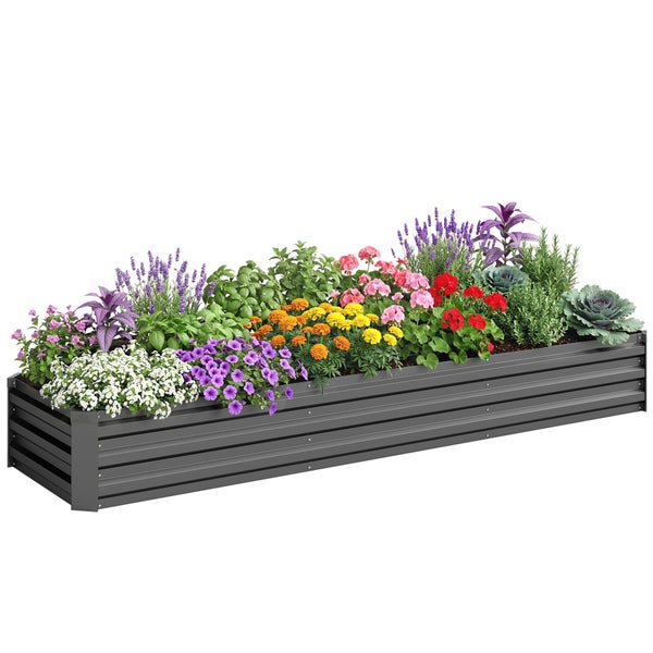 Dunkelgraues Metall-Hochbeet im Garten, bepflanzt mit Tomaten und grünem Blattgemüse, davor Gartenwerkzeuge und Handschuhe auf Erde.