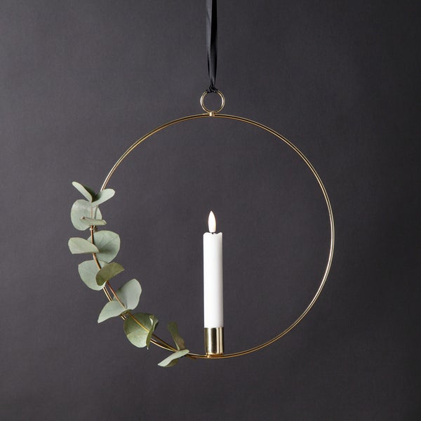 Dekorativer Kerzenhalter mit Eukalyptus-Zweig und Kerze an einem Band