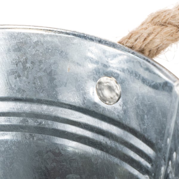 Detailansicht eines verzinkten Metalleimers mit einem Griff aus Seil.