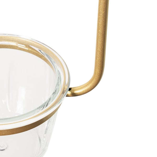 Nahaufnahme eines Pflanzgefäßes aus Glas mit goldenem Metallgestell