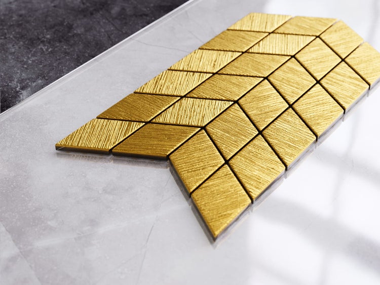 Küchenszene mit Spüle, Armatur, Arbeitsplatte, Küchenutensilien und goldenem Fliesenspiegel