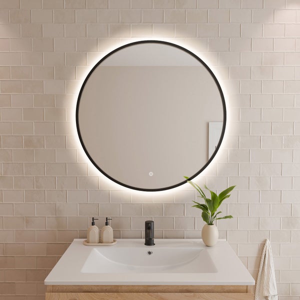 Runder LED Badezimmerspiegel mit integrierter Beleuchtung und Touch Sensor über einem Waschbecken mit Armatur vor einer Fliesenwand