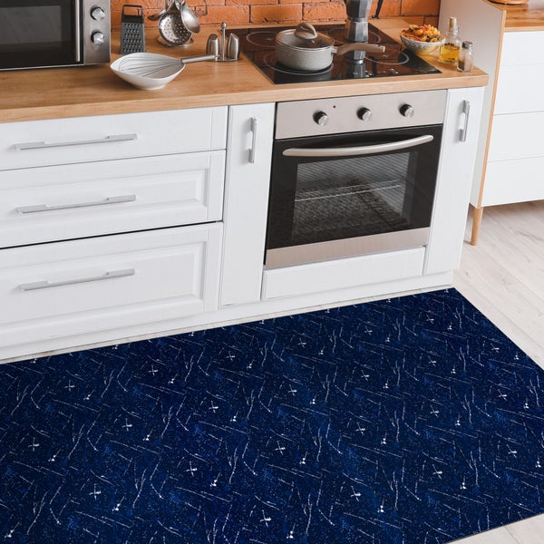 Küchenszene mit einem dunkel gemusterten Teppich vor einer Küchenzeile.