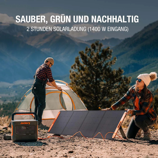 Tragbare Jackery Powerstation und faltbares Solarpanel in einer hellen Berglandschaft beim Camping mit einem Zelt und zwei Personen.