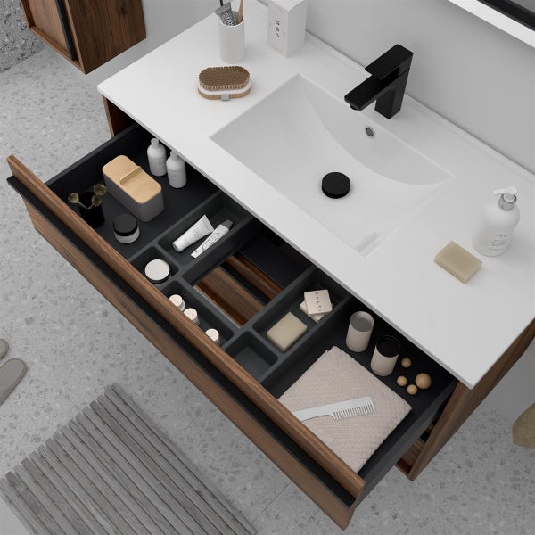 Moderner Waschtisch aus dunklem Holz mit weißem Waschbecken, schwarzer Armatur und perfekt organisiertem Schubladensystem für Badutensilien.