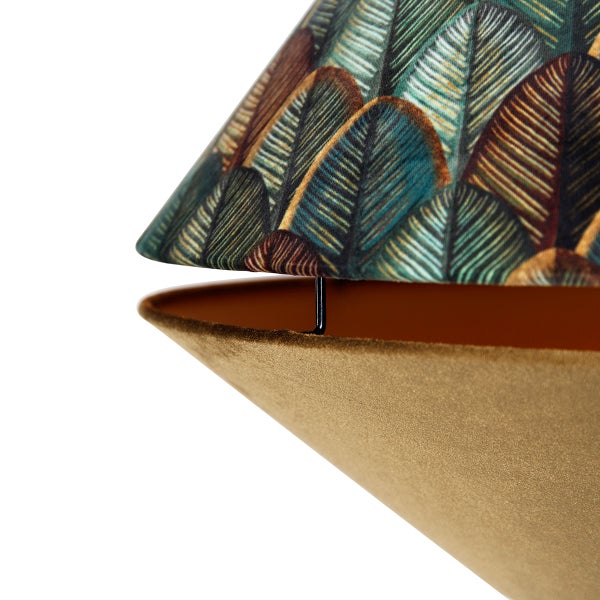 Nahaufnahme eines Lampenschirms mit Blattmuster oben und samtigem Stoff unten.