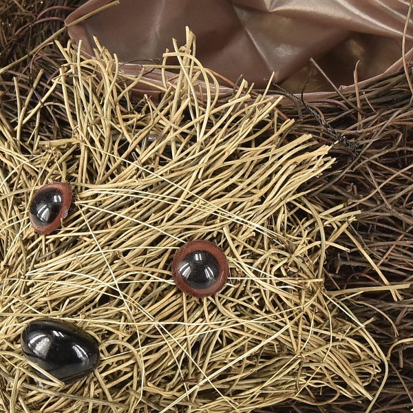Dekorative Igel Figur aus Naturmaterialien wie Stroh und Ästen mit Kunststoffaugen.