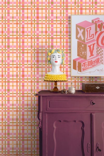 Vlies-Tapete mit buntem Karomuster in einem modern eingerichteten Raum mit violetter Kommode und Dekoration.