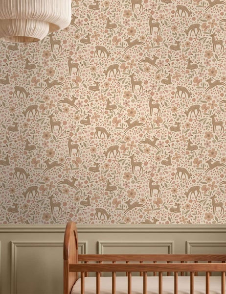 Tapete mit Reh und Blumen Muster für Kinderzimmer über einem hölzernen Kinderbett und Wandpaneelen