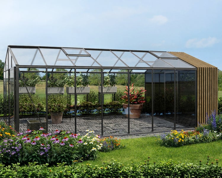 Modernes Gewächshaus mit Metallrahmen, Glaswänden und Holzlamellen-Anbau in einem Garten mit Pflastersteinen.