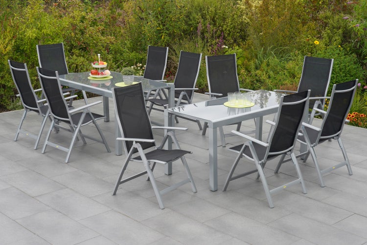 Gartenszene mit Gartentischen und Gartenstühlen auf einer Terrasse