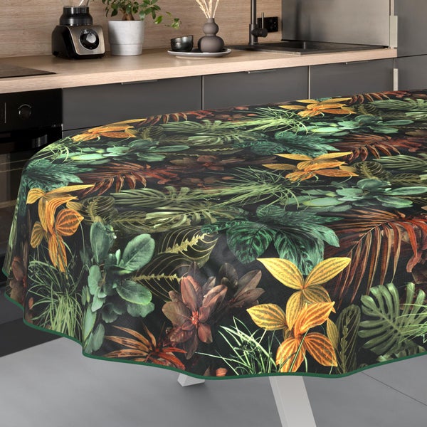 Ovale Tischdecke mit tropischem Blättermuster in einer modern eingerichteten, organisierten Küche mit Arbeitsplatte in Holzoptik.