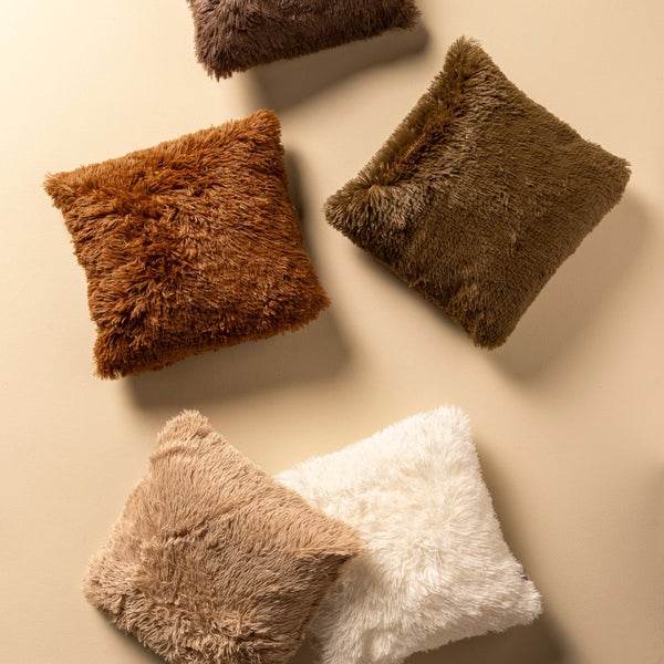 Mehrere flauschige Kissen in verschiedenen Farbtönen