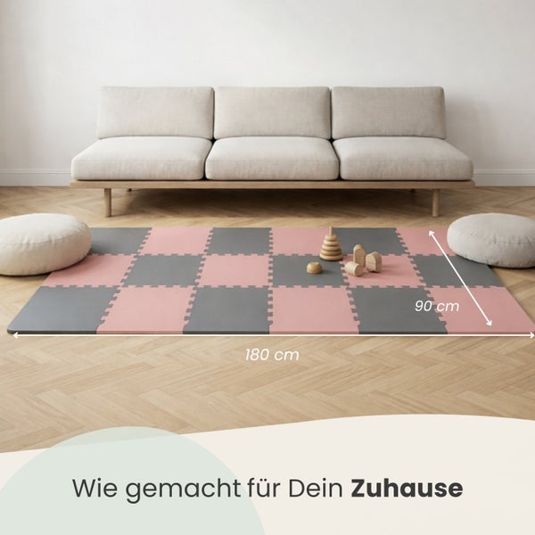 Puzzle-Spielmatte aus Schaumstoff in Grau und Rosa mit den Maßen 180 mal 90 Zentimeter in einem hellen und organisierten Wohnzimmer.