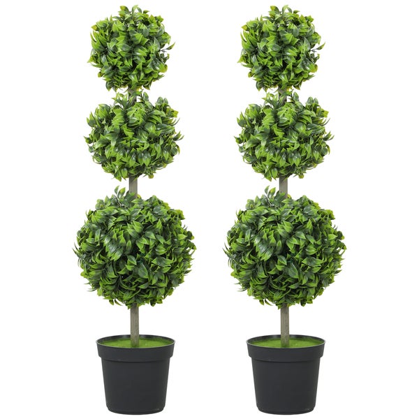 Innenraumszene mit zwei künstlichen Buchsbaumkugeln im Topf neben einem Sessel und einem Schrank