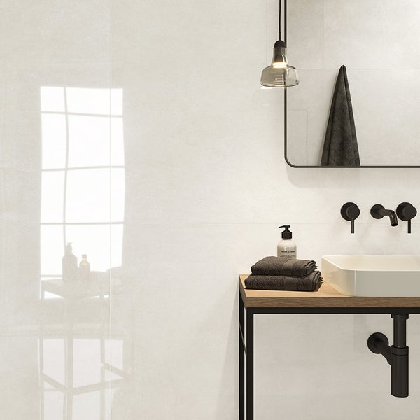 Modernes Badezimmer mit hellen Wandfliesen in Betonoptik, Waschtisch mit Holzplatte, schwarzer Armatur und Spiegel.