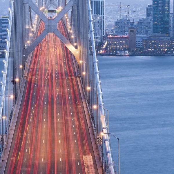 Autobahnbrücke mit abendlichem Verkehr und Stadtbild