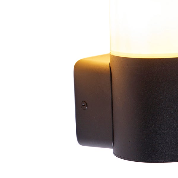 Detailansicht einer Außenwandleuchte mit beleuchtetem Zylinder und Wandhalterung aus Metall.