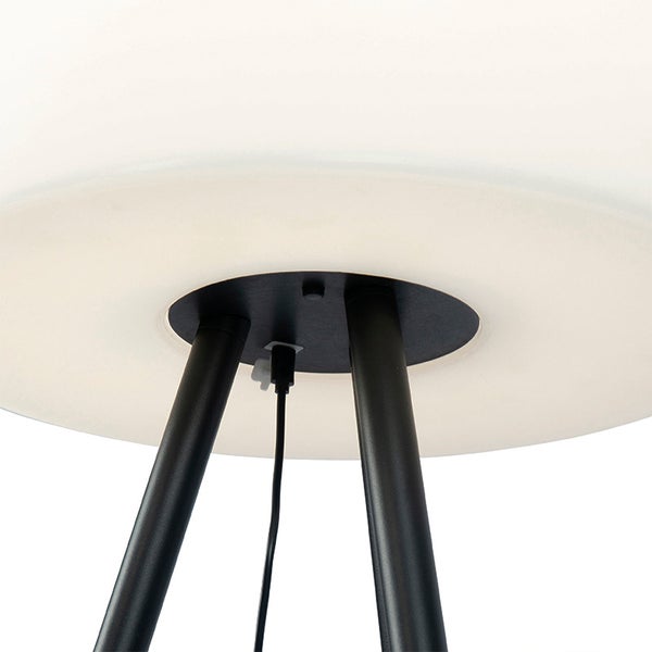 Detailansicht der Unterseite einer Lampe mit weißem Schirm, schwarzen Stativbeinen und USB-Ladeanschluss mit Kabel.