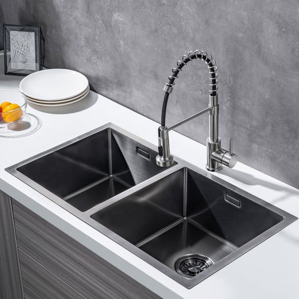 Moderne Edelstahl Küchenspüle mit zwei Becken und hoher Profi Armatur mit Spiralfeder auf einer weißen Arbeitsplatte in einer Küche.