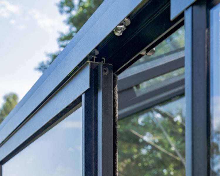 Detailaufnahme eines Aluminiumprofils mit Bürstendichtung und Glaselement für eine Terrassenüberdachung oder ein Gewächshaus.