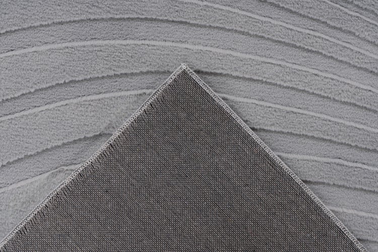 Detailaufnahme von einem Teppich mit strukturierter Oberfläche und erkennbarer Unterseite