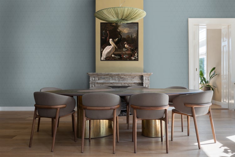 Esszimmer mit ovalem Esstisch, Stühlen und Wandbild über dem Kamin.