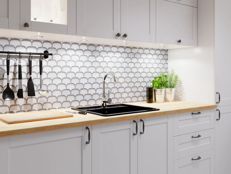 Helle Küche mit Arbeitsplatte aus Holz, schwarzem Spülbecken, Chrom-Armatur und Fliesenspiegel im Fischschuppen-Design.