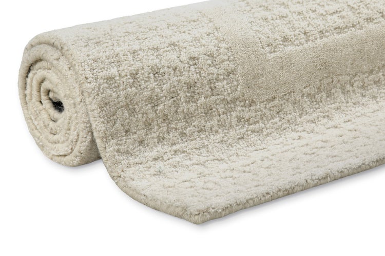 Eingerollter strukturierter Teppich mit weichem Flor.