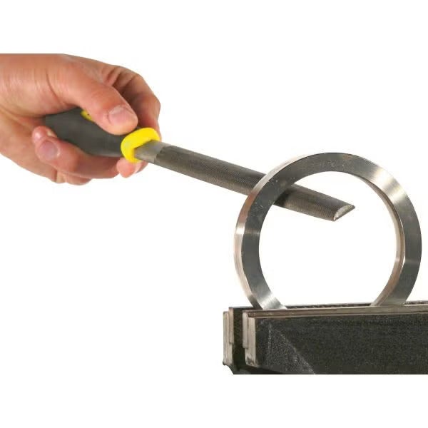 Eine Hand bearbeitet einen Metallring in einem Schraubstock mit einer Halbrundfeile.