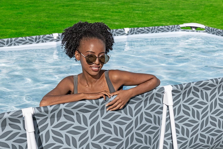 Frau im Aufstellpool mit Rahmen und Blattmuster im Garten.