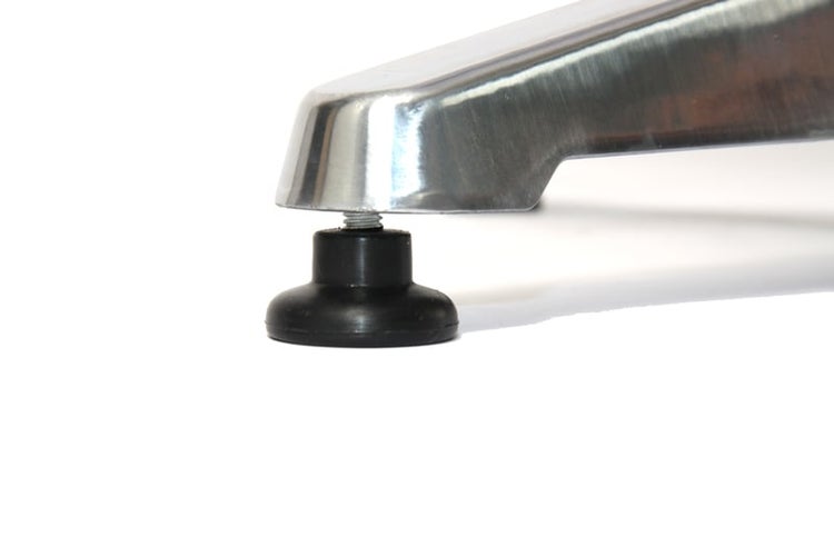 Detailansicht eines Möbelbeins mit Nivellierfuß aus Metall und Kunststoff