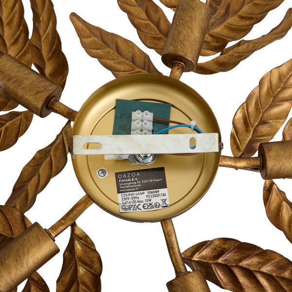Innenansicht der Deckenbefestigung einer goldfarbenen Deckenleuchte im Blattdesign mit elektrischen Anschlüssen, Montagebügel und Typenschild.