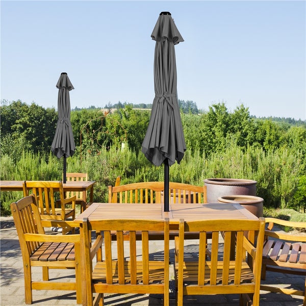 Gartenmöbel-Set mit Holztischen, Stühlen, Bänken und Sonnenschirmen im Außenbereich