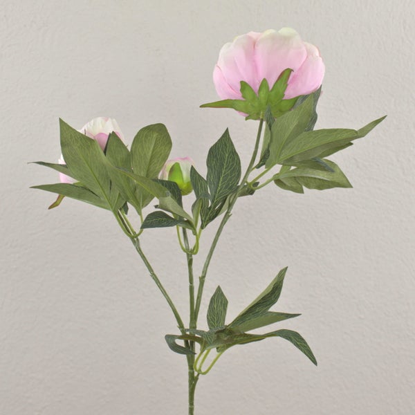 Künstliche Pfingstrose in Rosa mit geschichteten Blütenblättern aus Textil und grünen Blättern.