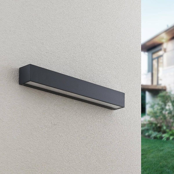 Moderne, schwarze Außenwandleuchte in rechteckiger Form an einer hellen, strukturierten Hausfassade.