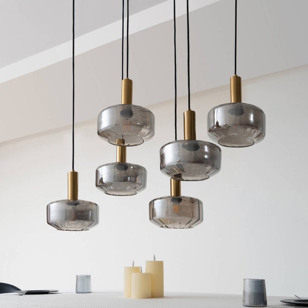 6-flammige Pendelleuchte mit rauchgrauen Glasschirmen und messingfarbenen Fassungen, hängend in verschiedenen Höhen.