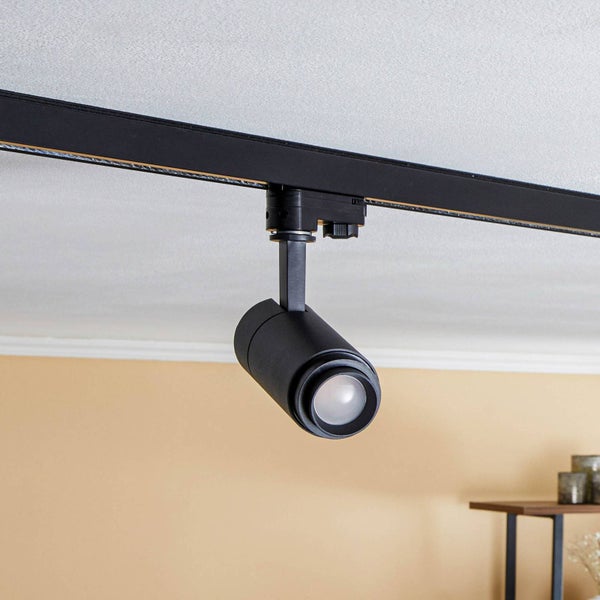 Schwarzer, verstellbarer Strahler für ein Schienensystem, montiert an einer schwarzen Schiene an der Decke.