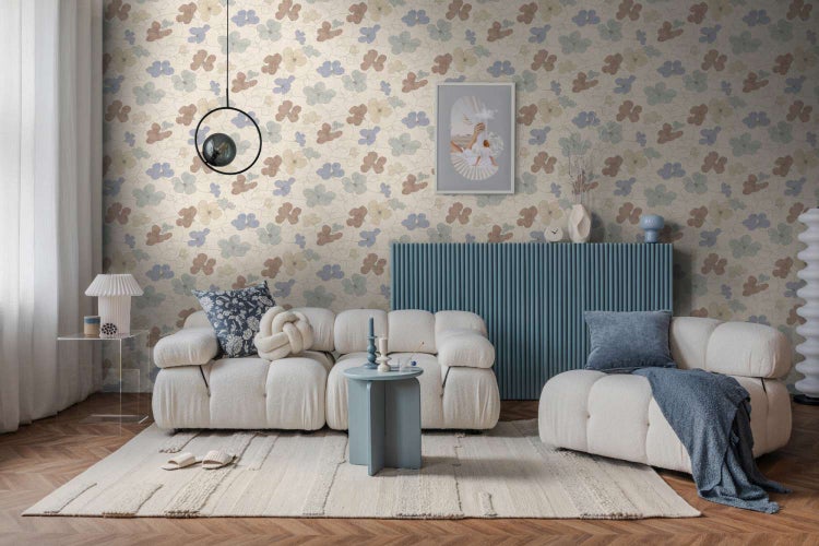 Wohnzimmer mit blumig tapezierter Wand, modernem Sofa in Modulbauweise, geriffeltem Sideboard und stilvoller Dekoration auf einem Teppich.