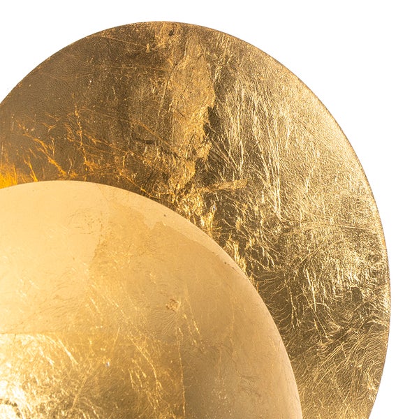 Detailansicht einer runden goldenen Wandleuchte