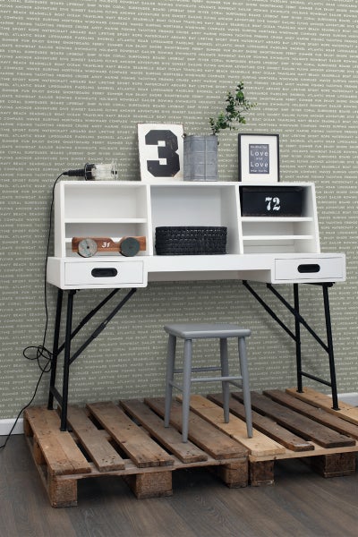 Schreibtisch mit Ablageflächen und grauem Hocker auf Holzpaletten